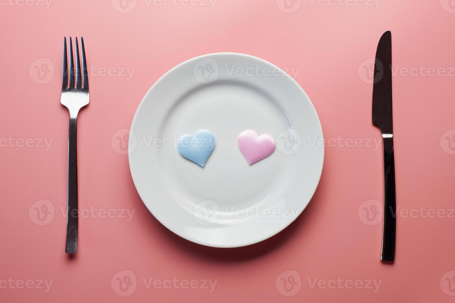 Two hearts in plate with cutlery. Romantic dinner in restaurant concept. Meeting of lovers at wedding reception. photo