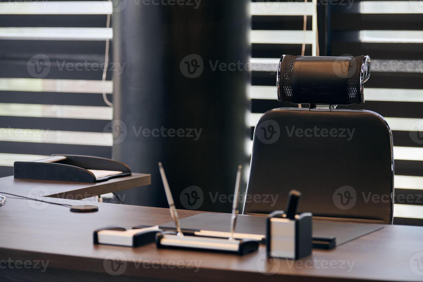 lugar de trabajo de la oficina de negocios. lugar de trabajo para jefe, jefe u otros empleados. mesa y silla cómoda. luz a través de las persianas entreabiertas foto