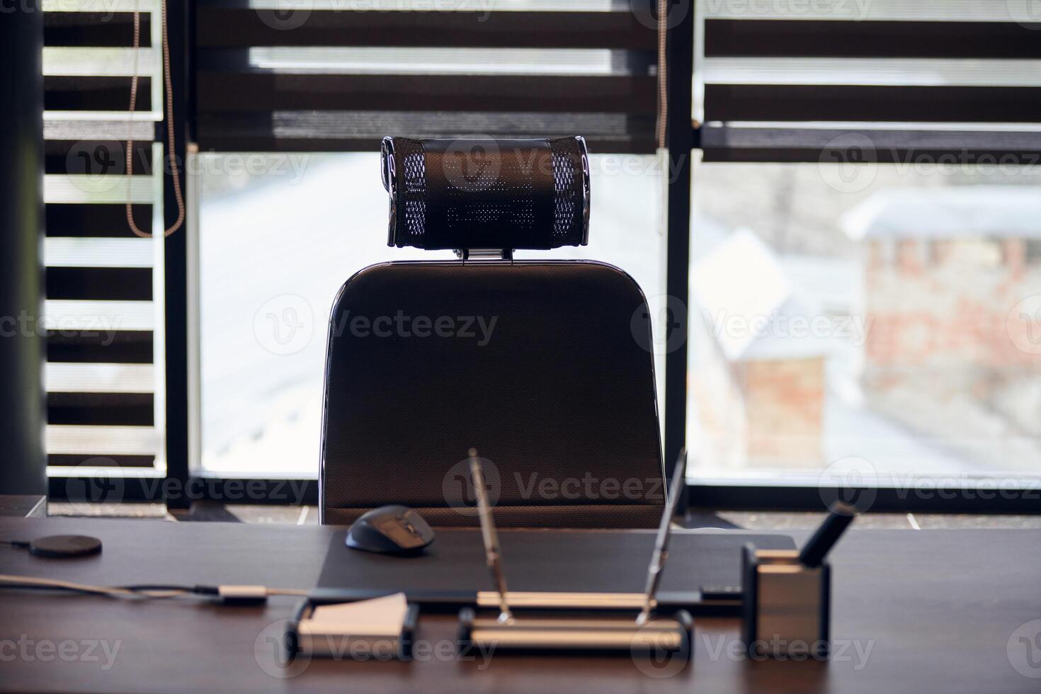 lugar de trabajo de la oficina de negocios. luz solar en el lugar de trabajo para jefe, jefe u otros empleados. mesa y silla cómoda. luz a través de las persianas entreabiertas foto