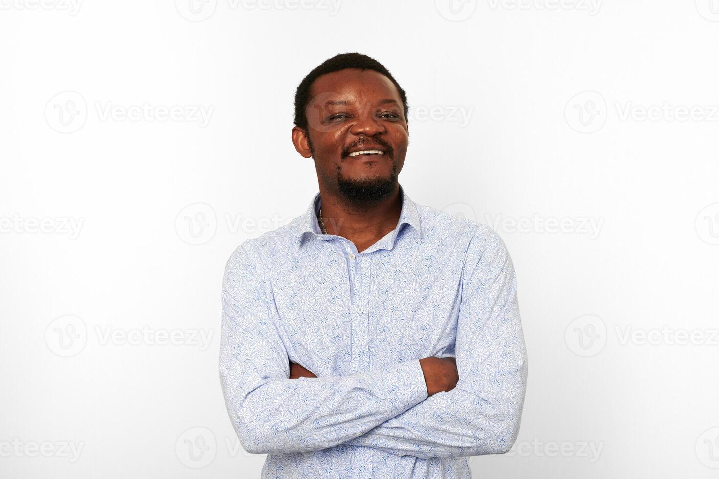 feliz hombre negro afroamericano con los brazos cruzados en camisa casual brillante fondo blanco aislado foto
