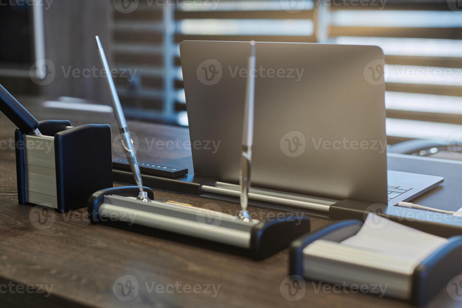 Modern office workplace. Business laptop in work place for chief, boss or other employees. Notebook on work table. Office large corporation. Light through half open blinds photo