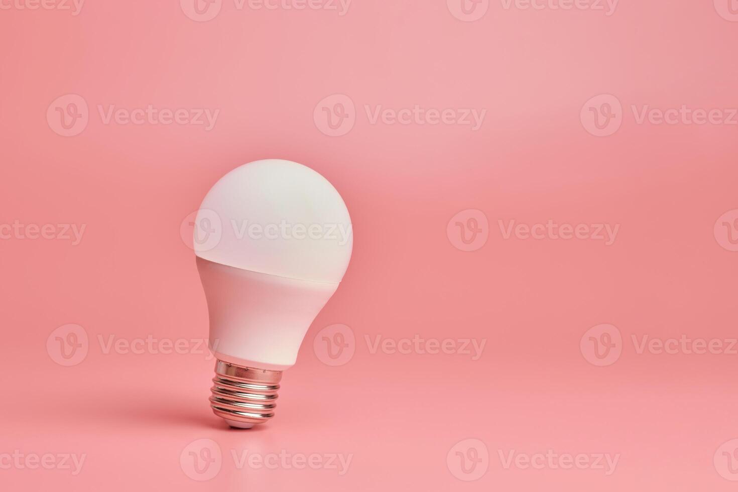 Light bulb, copy space. Energy saving minimal idea concept.Pink background. photo