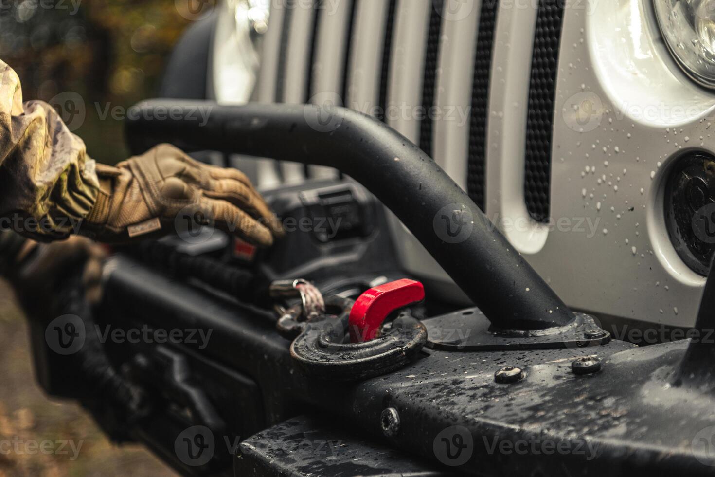 A Man Using SUV Electric Winch to Recover His Vehicle photo