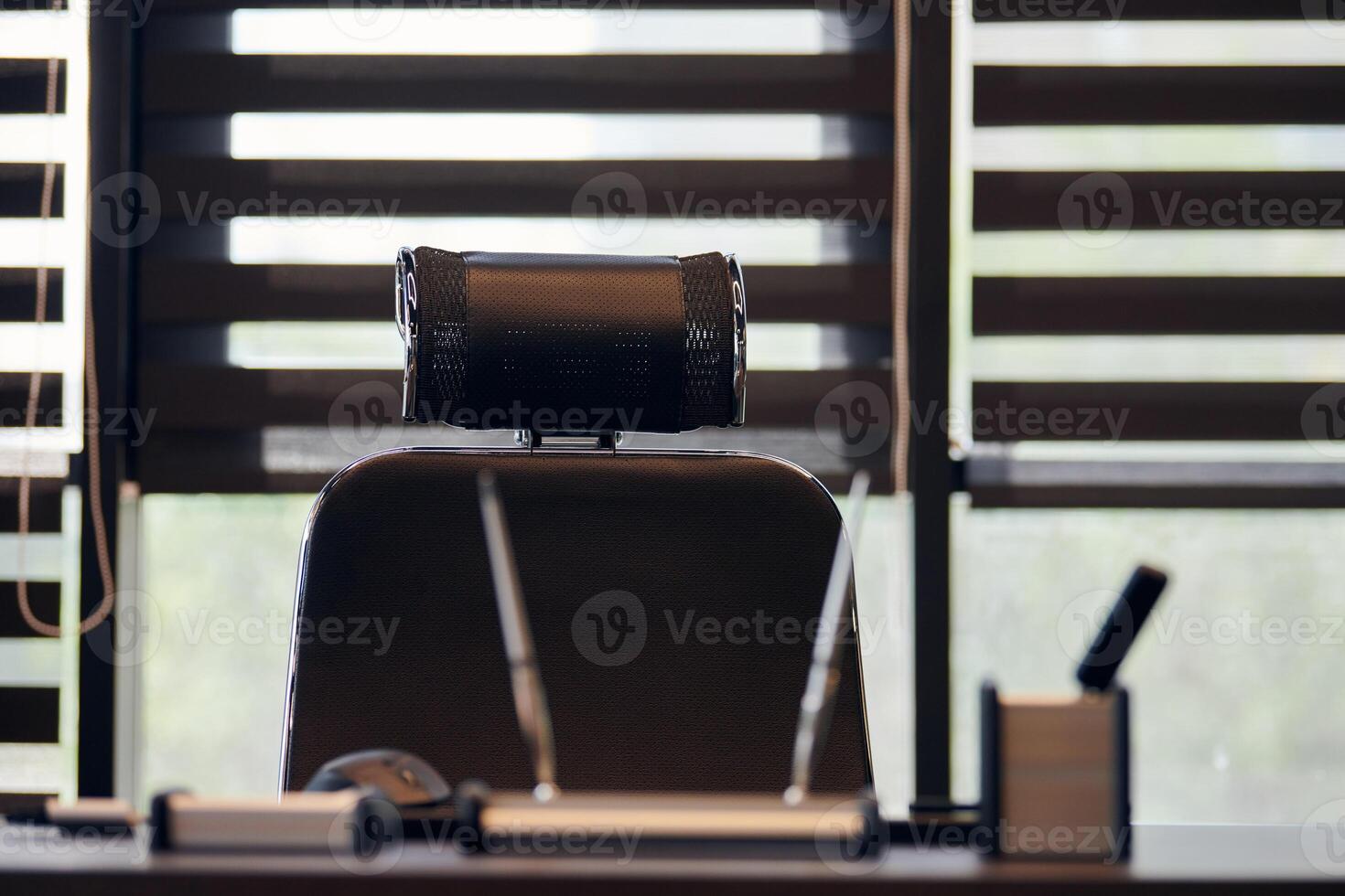 Business office workplace. Work place for chief, boss or other employees. Table and comfortable chair. Light through the half open blinds photo