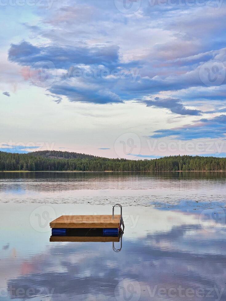 Swimming island in Sweden on a lake at sunset. Clouds reflected in the water. photo