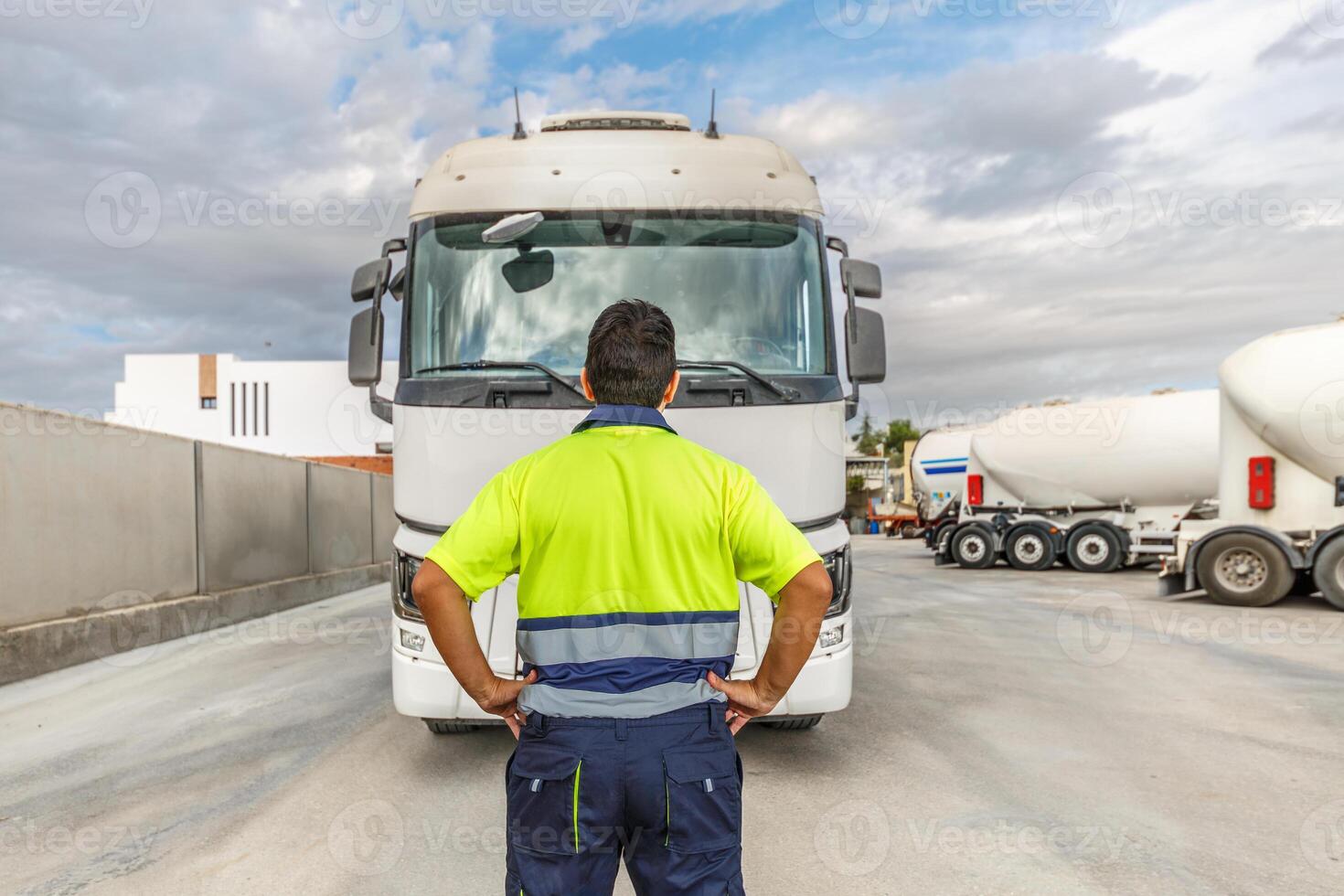 Unrecognizable man mechanic standing in front of parked truck in service center photo