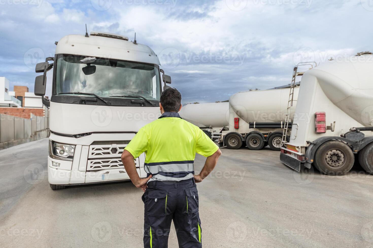 Unrecognizable man mechanic standing in front of parked truck in service center photo