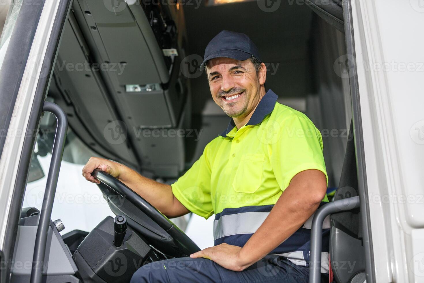 alegre masculino conductor sentado en camión mientras mirando a cámara foto