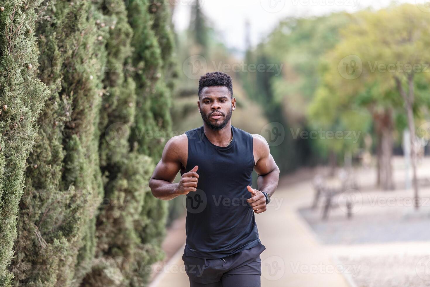 joven africano americano hombre en ropa de deporte corriendo en parque foto