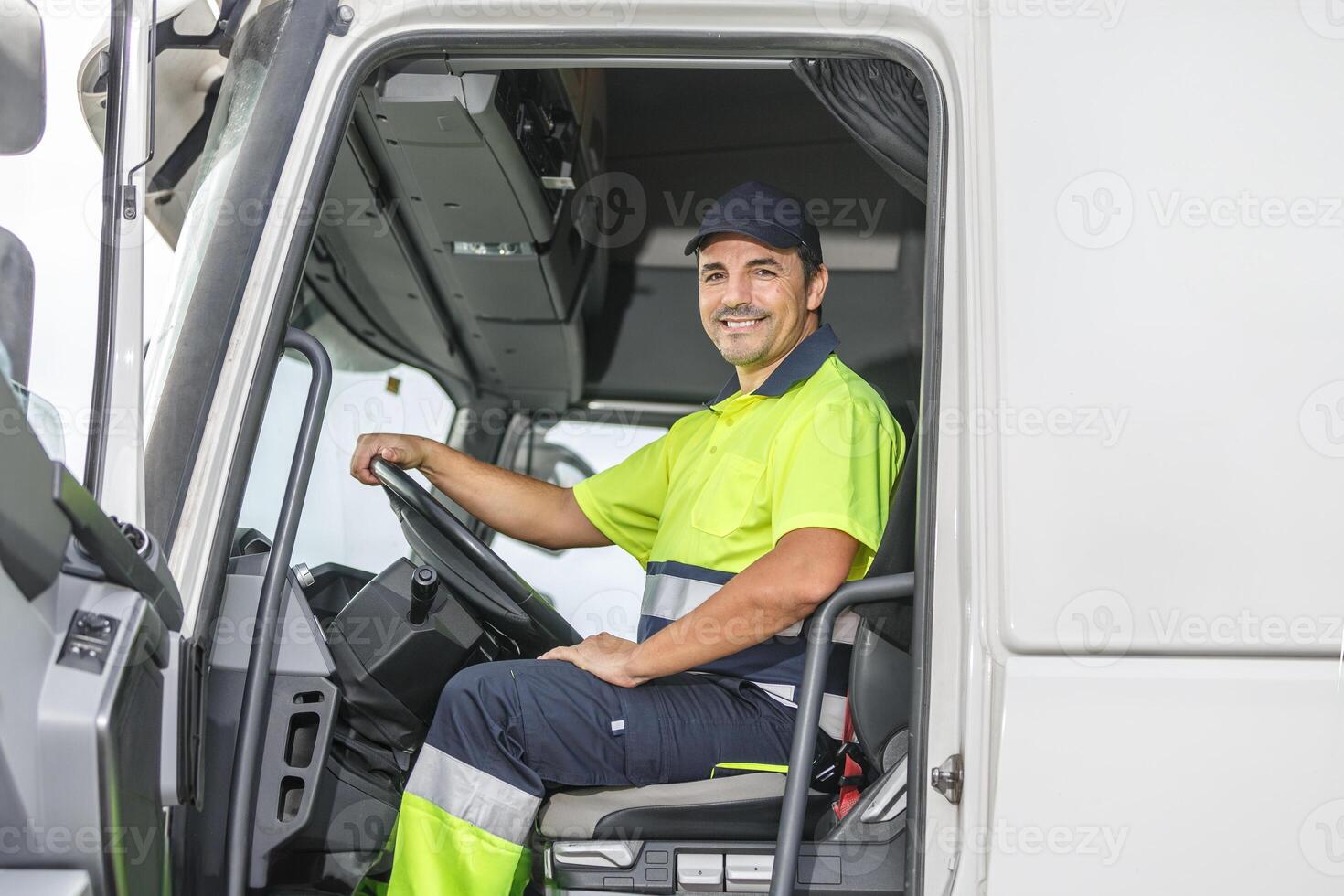 Smiling male driver sitting in truck and looking at camera photo