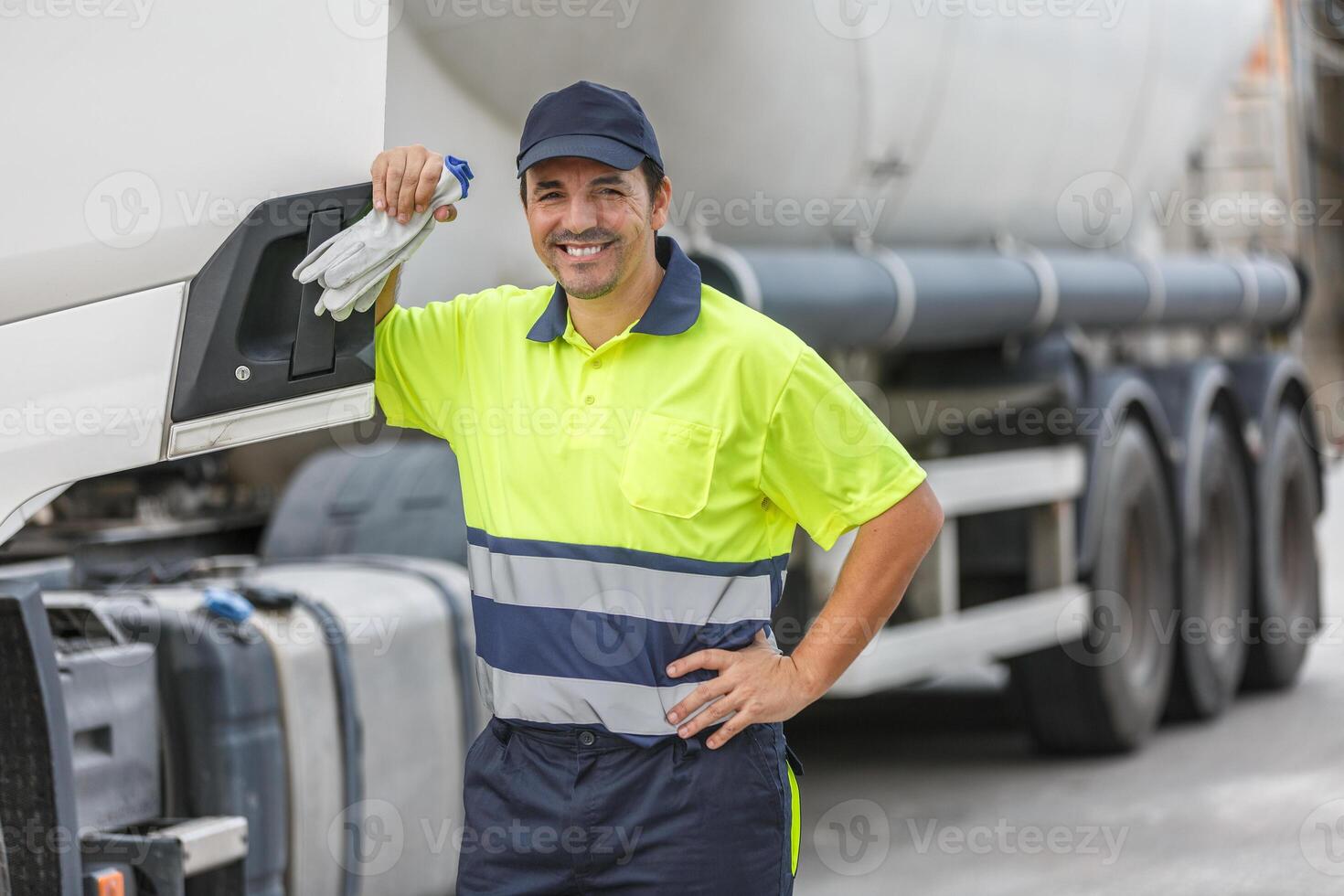 sonriente camión conductor en pie por vehículo terminado borroso antecedentes foto