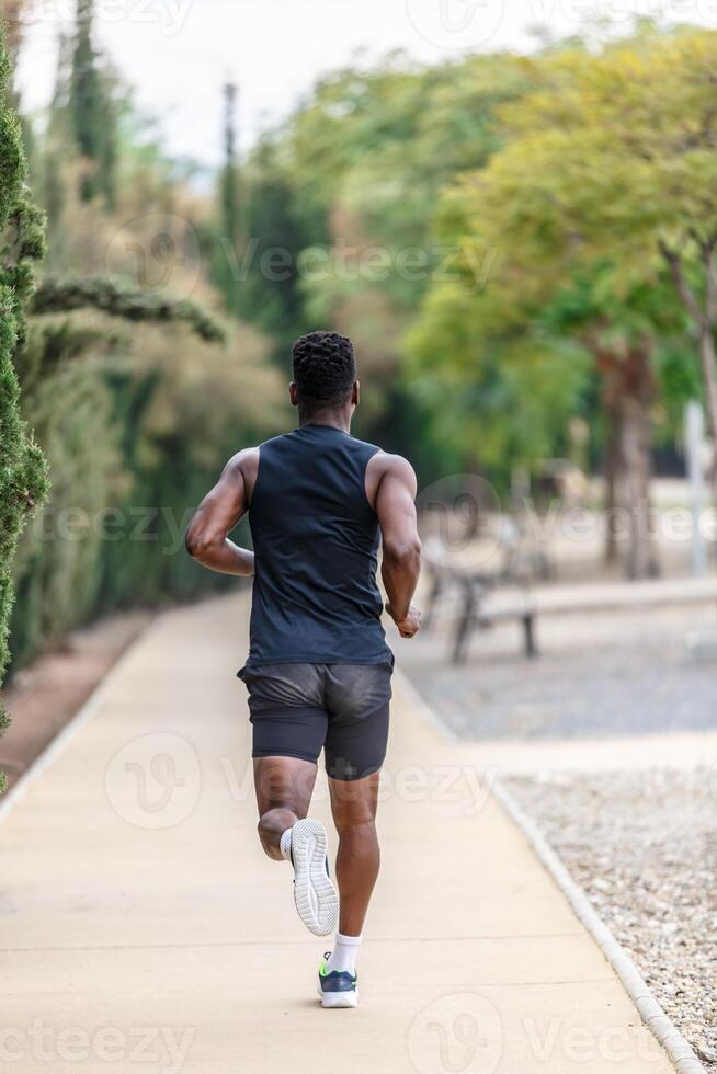 anónimo africano americano deportista corriendo a lo largo parque durante aptitud formación foto