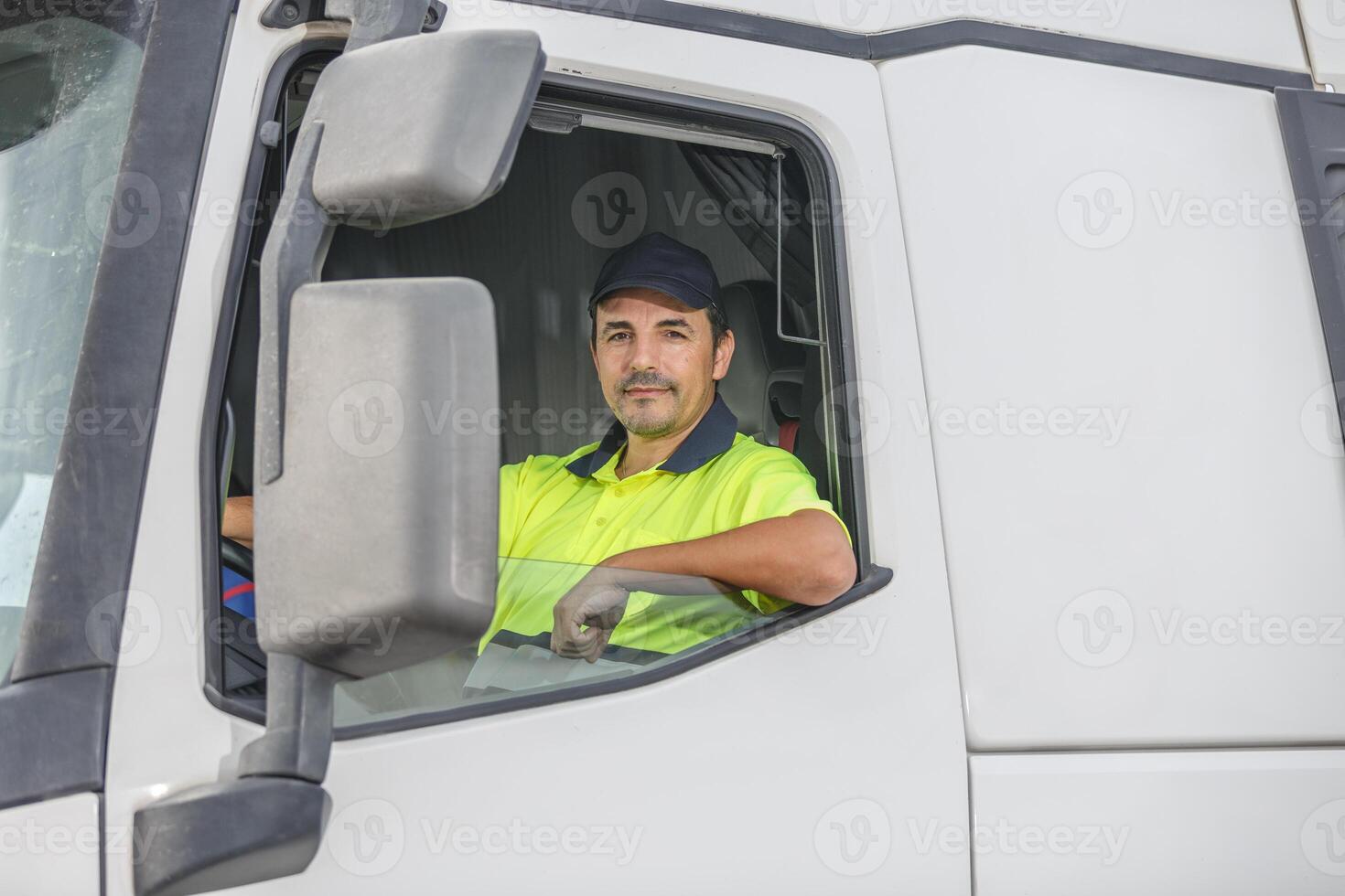 Confident male driver sitting in white truck and looking at camera photo