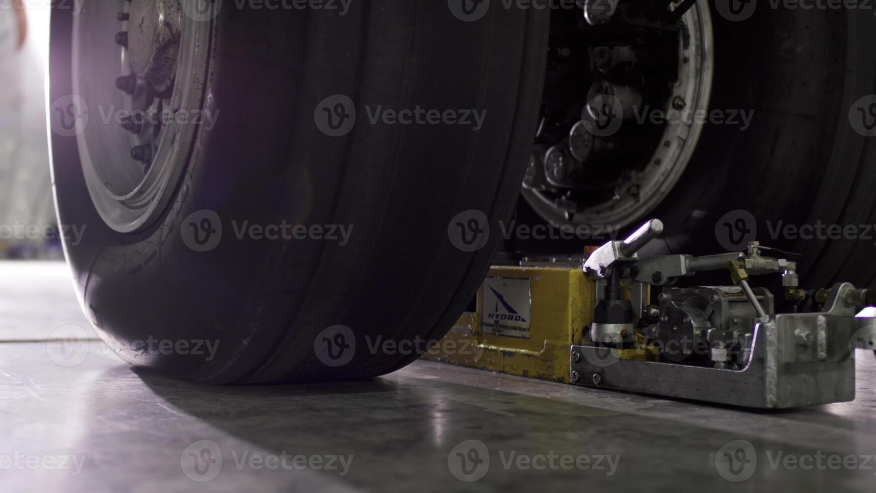 Airport worker checking chassis. Engine and chassis of the passenger airplane under heavy maintenance. Engineer checks the aircraft chassis and engine. photo