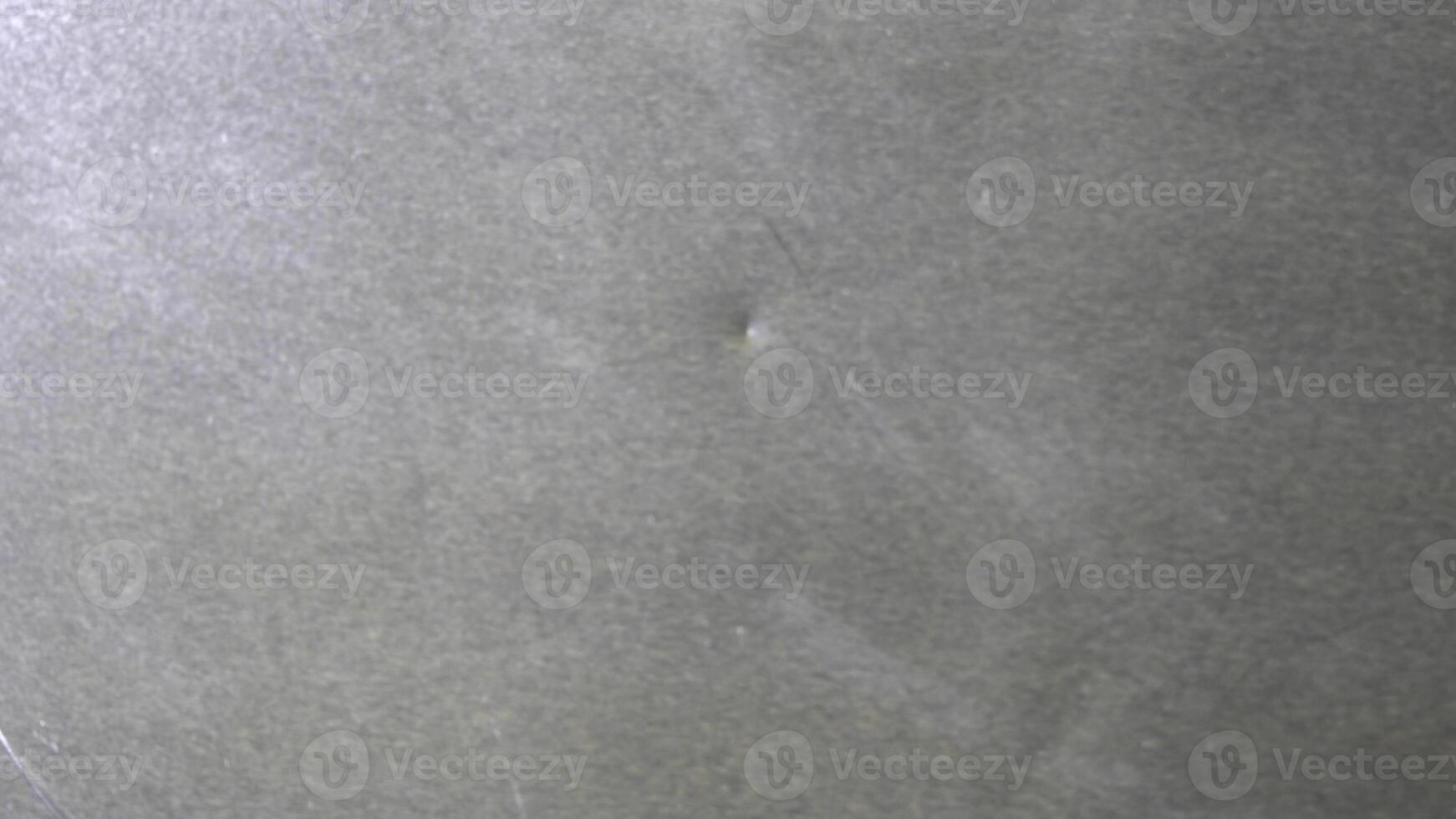 Top view of liquid oil flowing on metal sheet. Movement of liquid oily substance on grey, metal background. photo