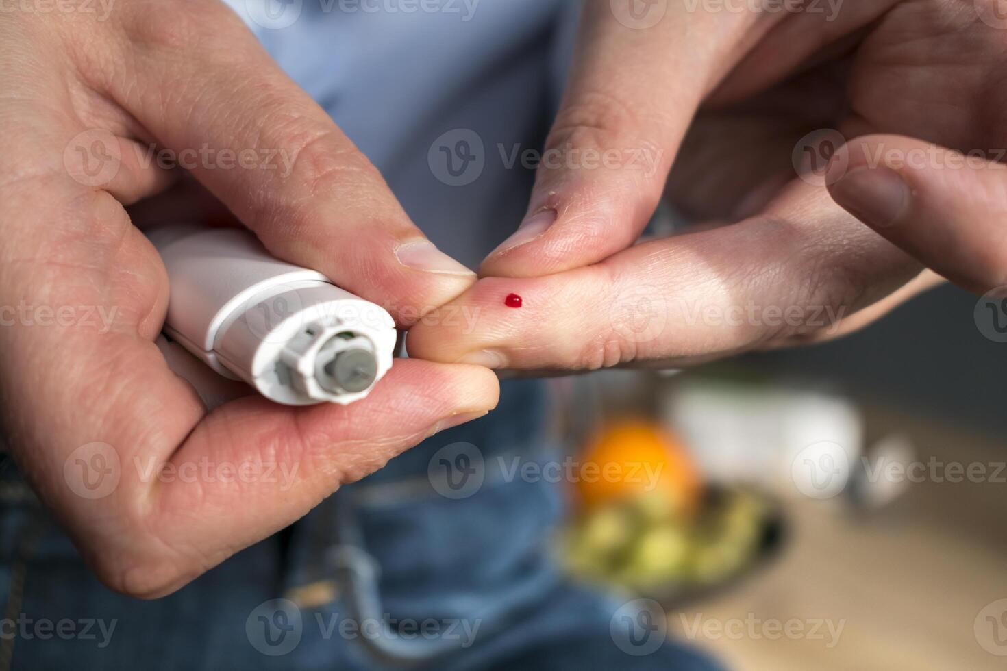 Woman pricking her finger to check blood glucose level with glucometer, test blood glucose for diabetes photo