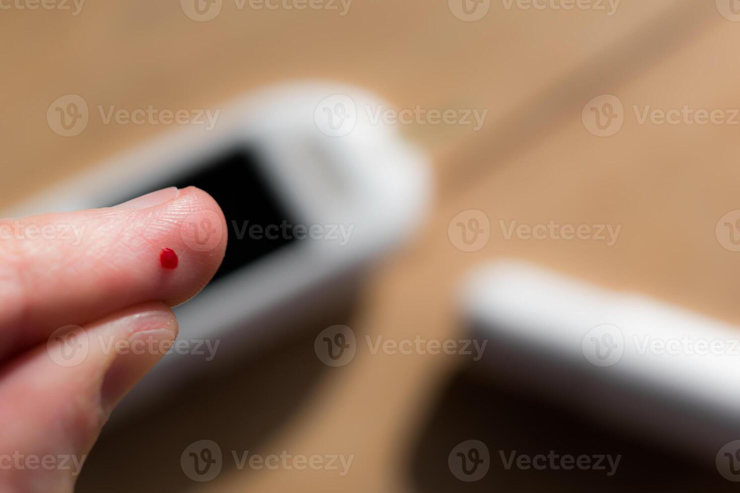 Woman pricking her finger to check blood glucose level with glucometer, test blood glucose for diabetes photo