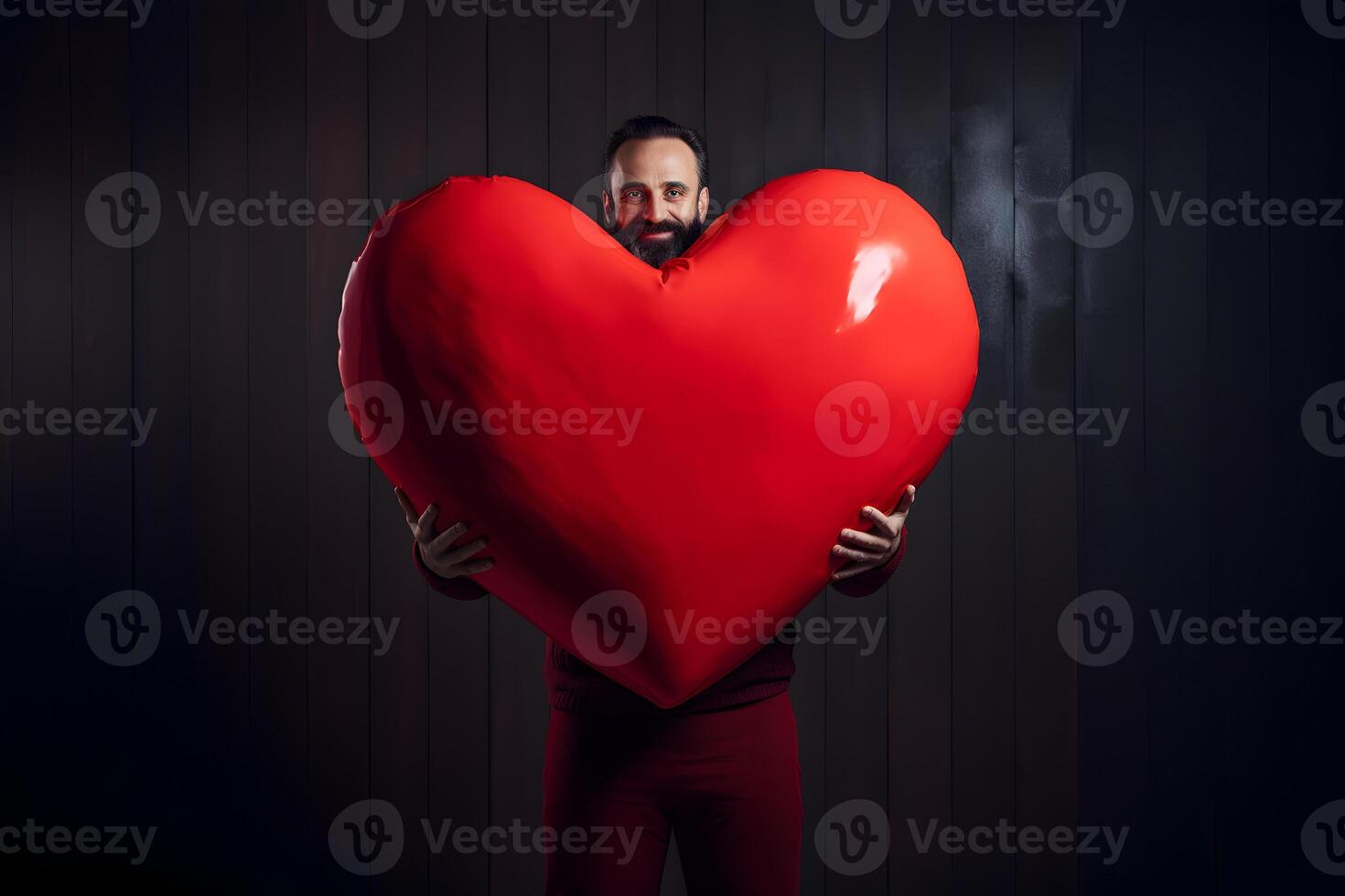 AI generated adult Caucasian man in red pants holding big red heart on black vertical wooden planks board wall background, neural network generated photorealistic image photo