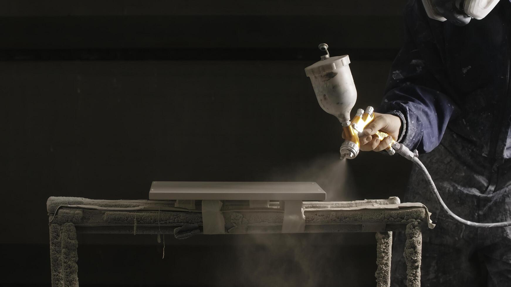Delhi, India - April 29, 2023. Close-up of man spray painting board in workshop. Creative. Epic painting of board in workshop. Professional spray painting of objects in workshop photo