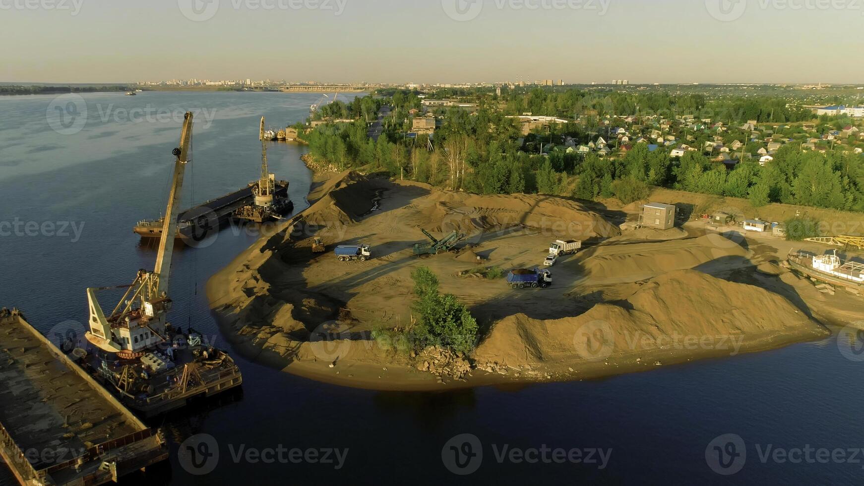 Drone flight over the sand and gravel mining on a sunny summer day near the river. Scene. Concept of heavy industry and machinery. photo