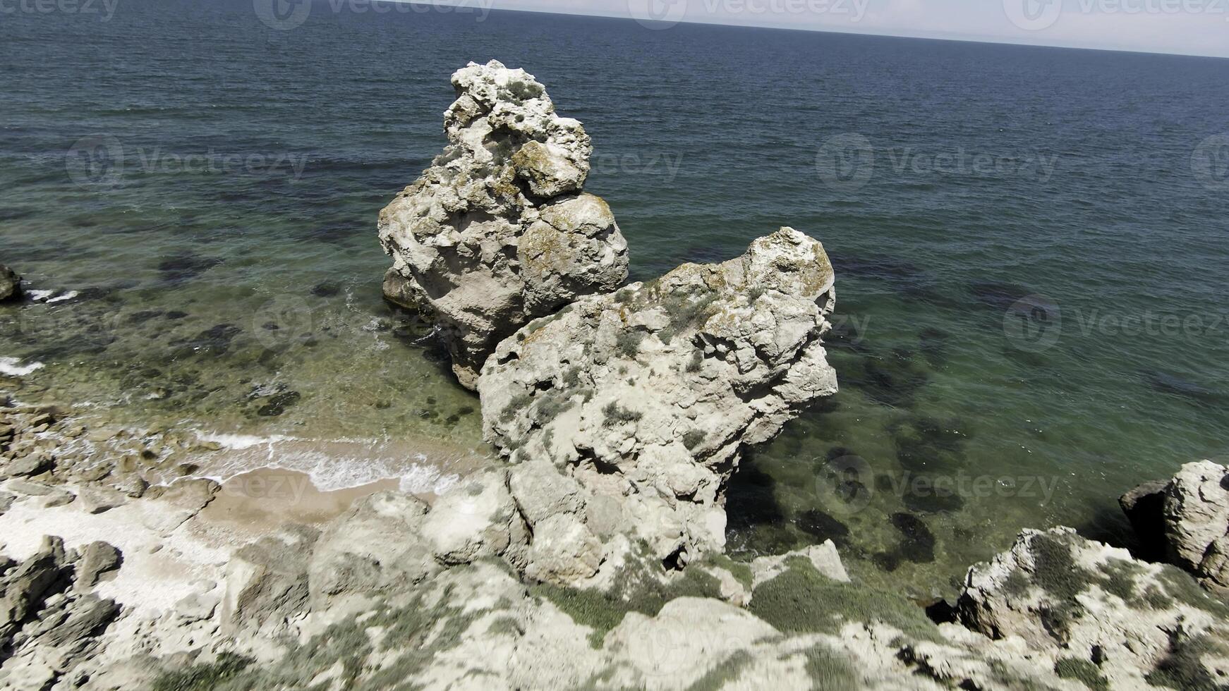 Sea view located next to the mountains.Action. Drone view of a beautiful seascape on large rocks near the sea and high hills. photo