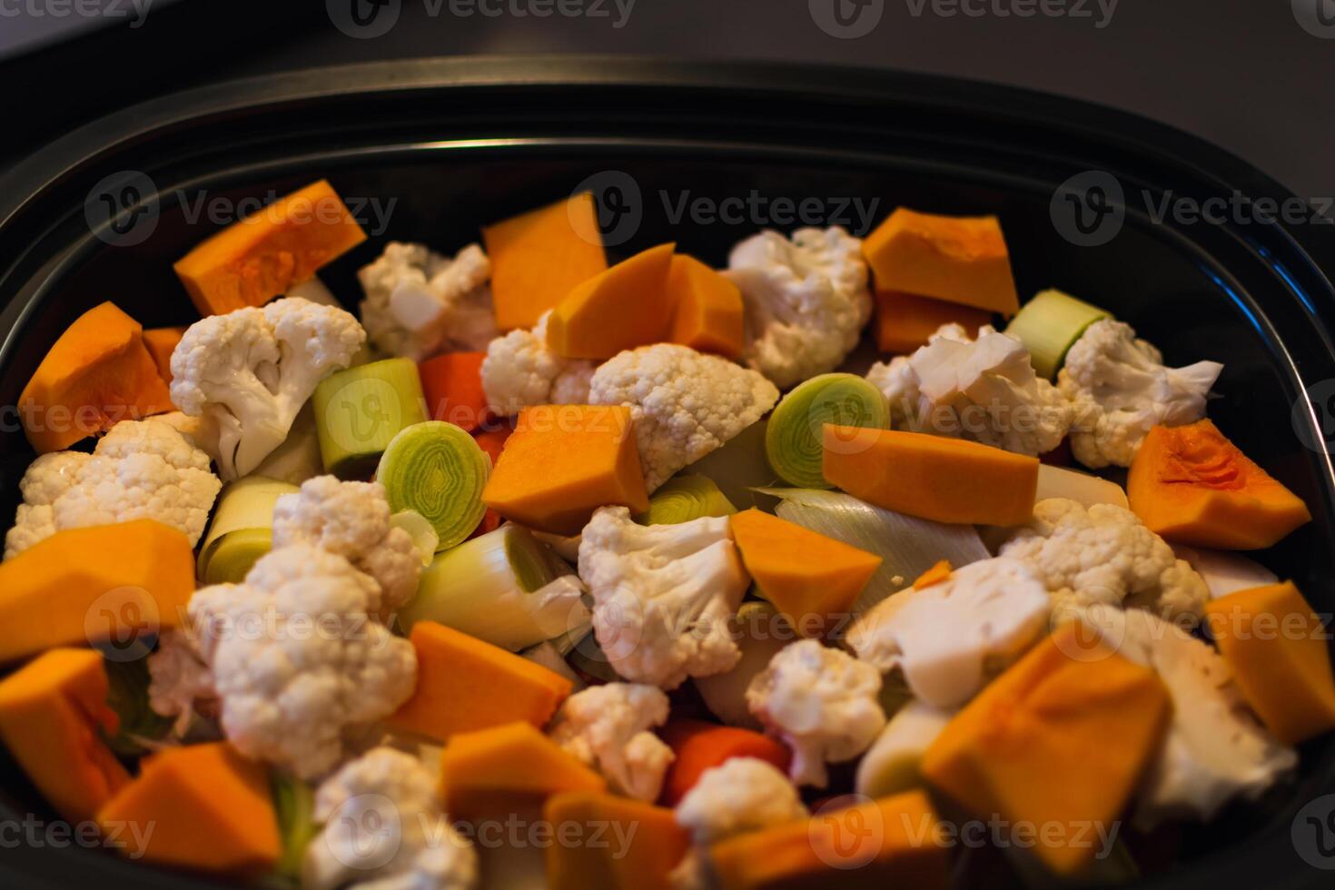 Raw vegetables cut into small pieces prepared for steaming, cauliflower, butternut, leek, carrot photo