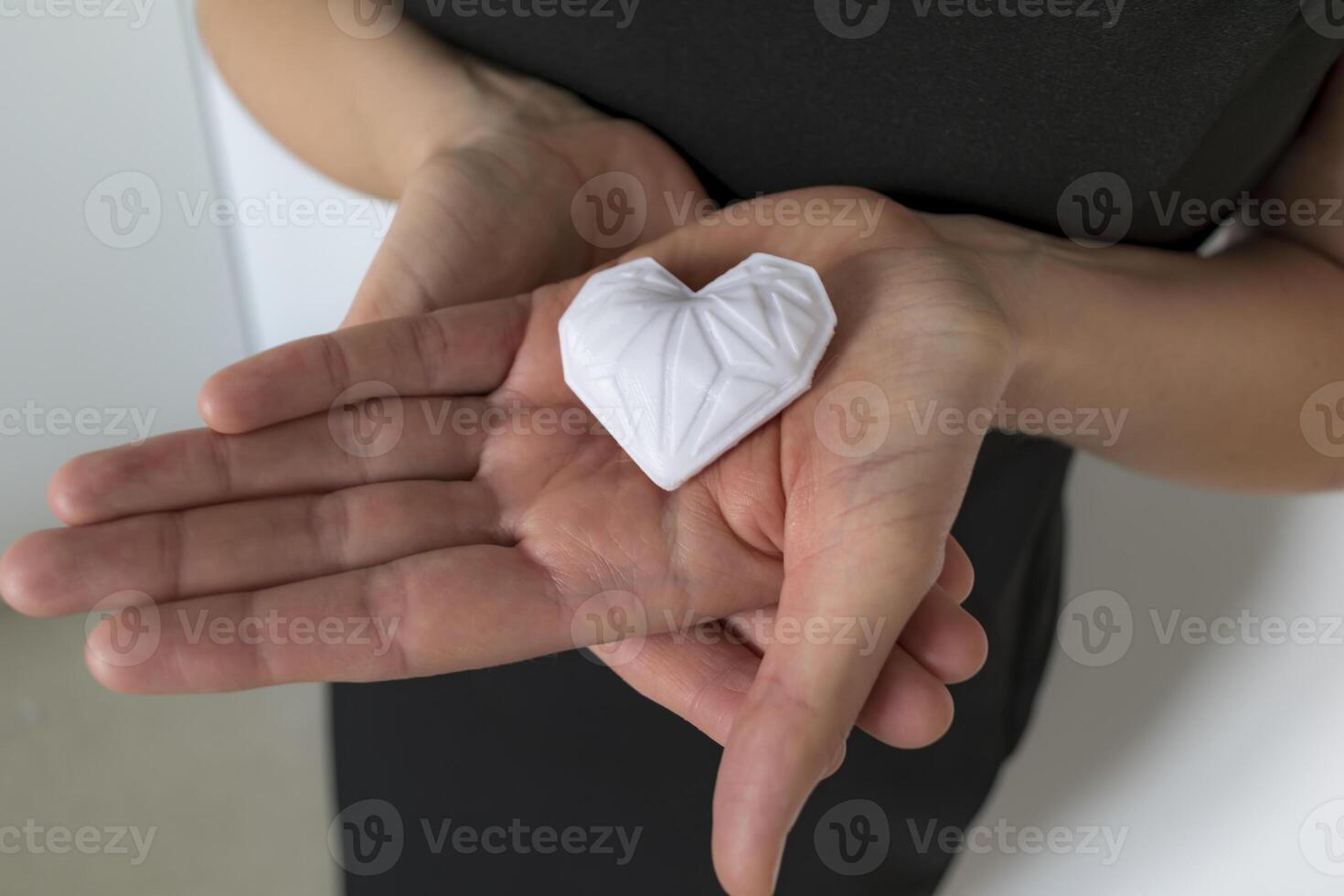 Woman holding white 3d printed heart. Ideal for diverse concept, love and health, gratitude and charity either technology photo