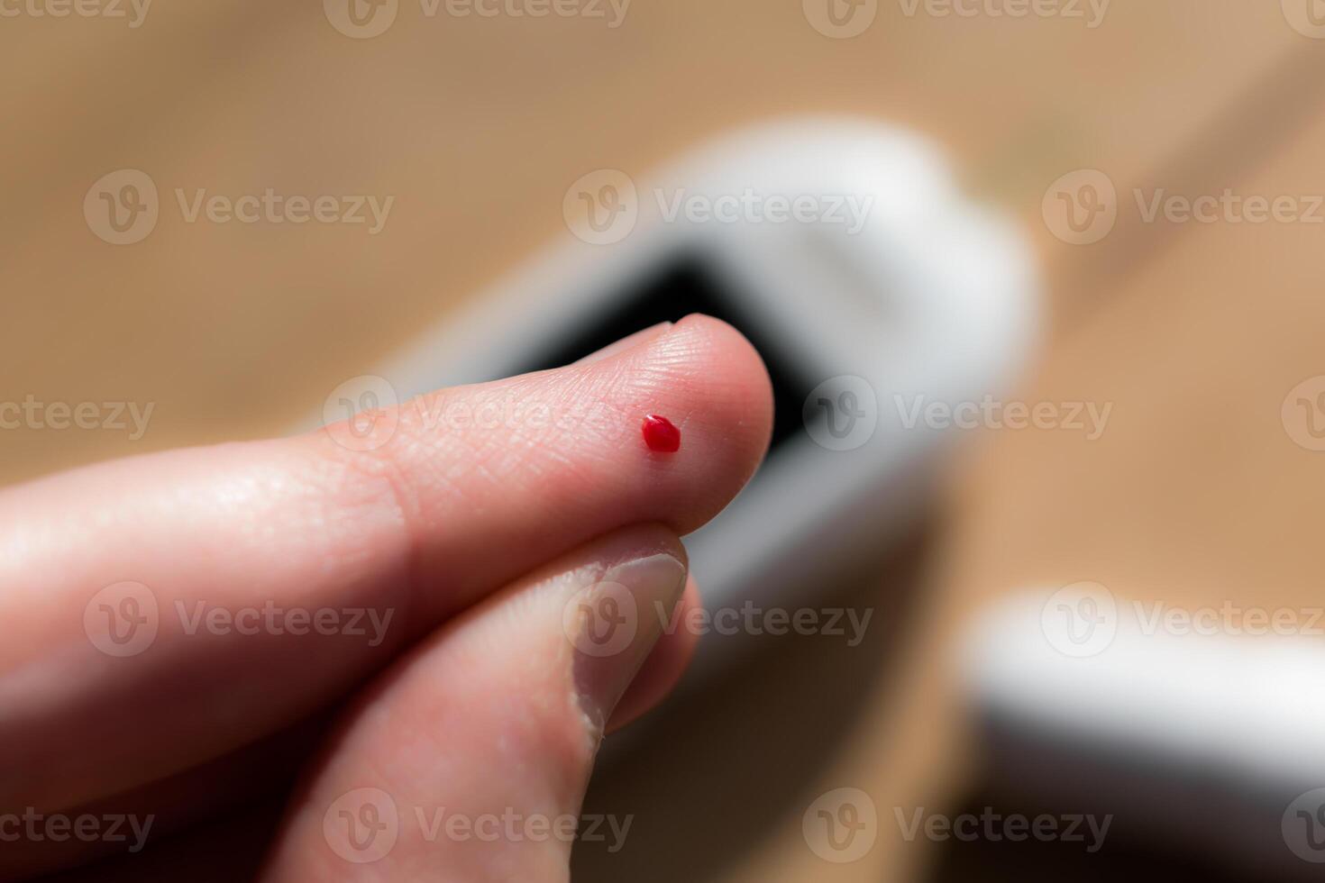 Woman pricking her finger to check blood glucose level with glucometer, test blood glucose for diabetes photo