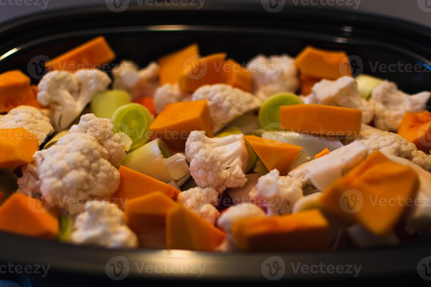Raw vegetables cut into small pieces prepared for steaming, cauliflower, butternut, leek, carrot photo