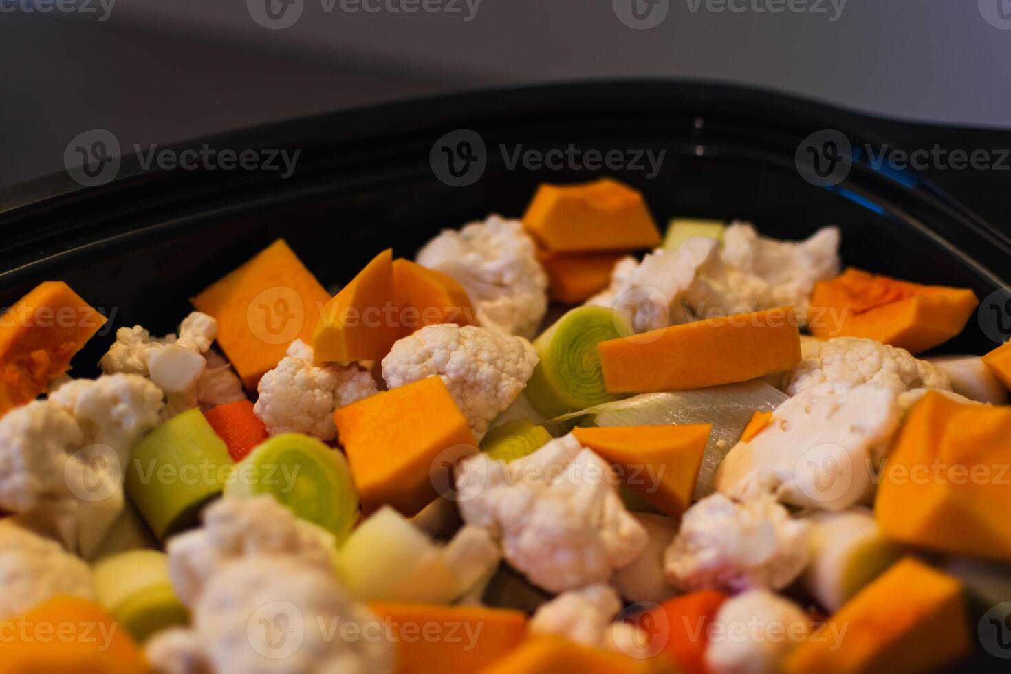 Raw vegetables cut into small pieces prepared for steaming, cauliflower, butternut, leek, carrot photo