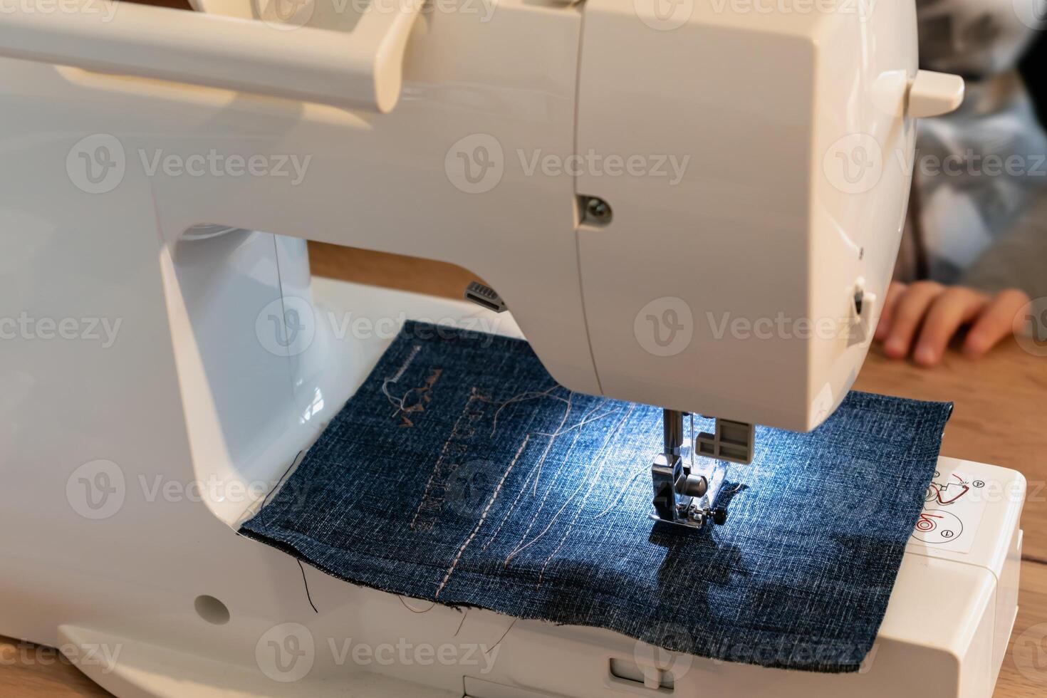 Man using a sewing machine with a blue garment, for repair work, customization, creation, upcycling photo