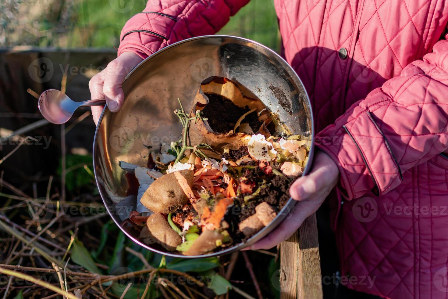 Person who put in a composter some kitchen waste like vegetables, fruits, eggshell, coffee grounds in order to sort and make bio fertilizer photo