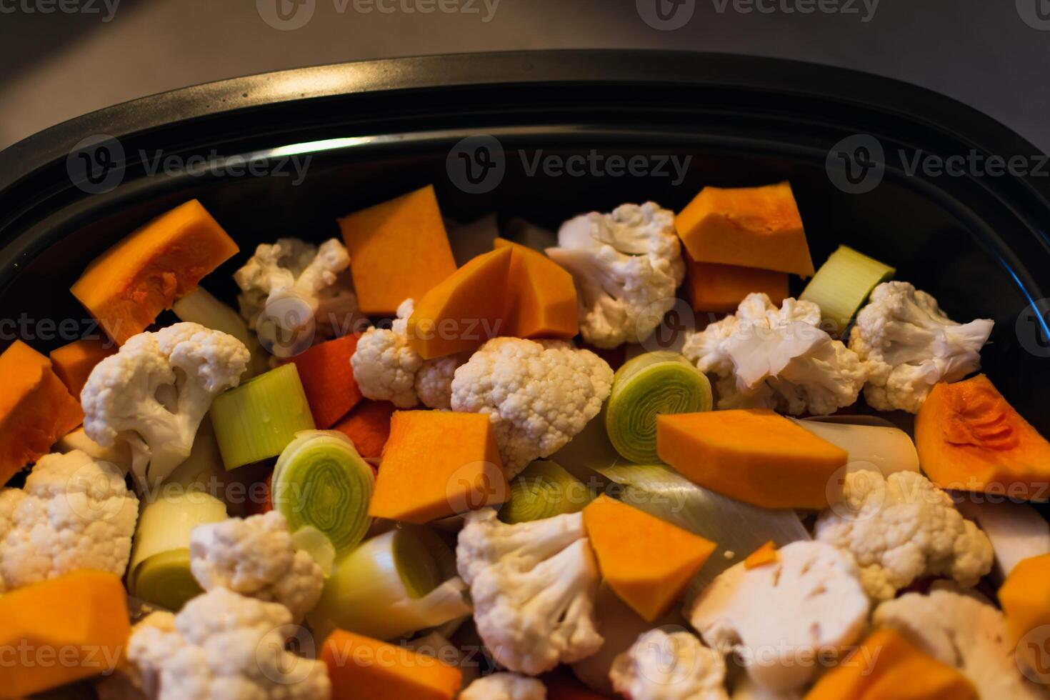 Raw vegetables cut into small pieces prepared for steaming, cauliflower, butternut, leek, carrot photo