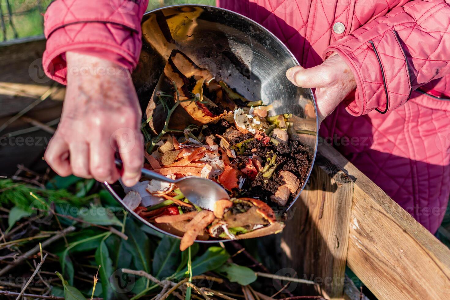 Person who put in a composter some kitchen waste like vegetables, fruits, eggshell, coffee grounds in order to sort and make bio fertilizer photo