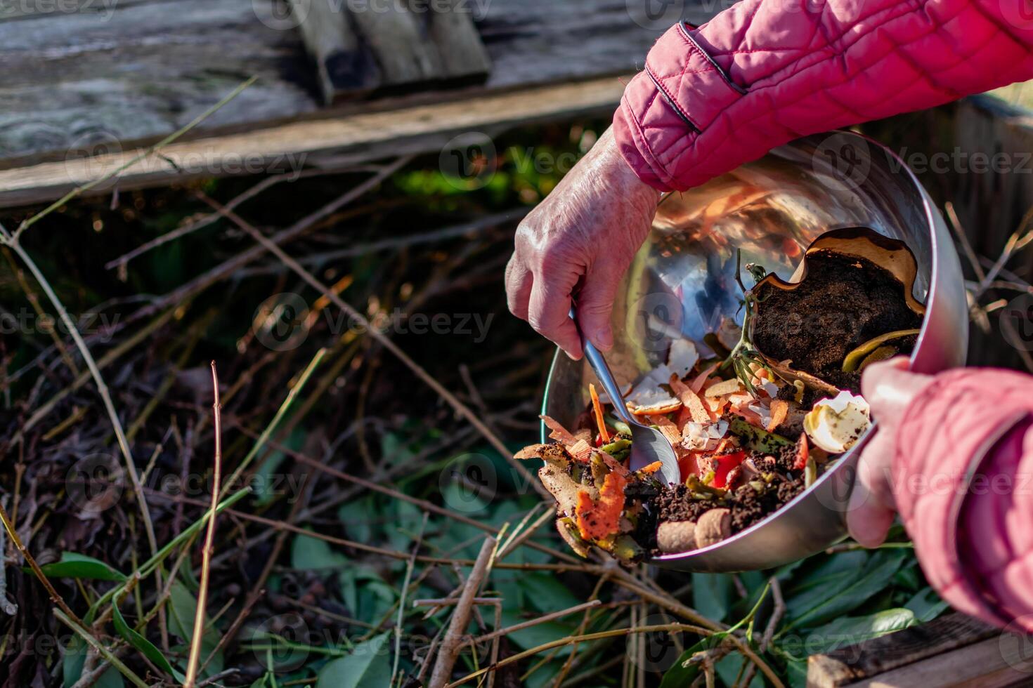 Person who put in a composter some kitchen waste like vegetables, fruits, eggshell, coffee grounds in order to sort and make bio fertilizer photo