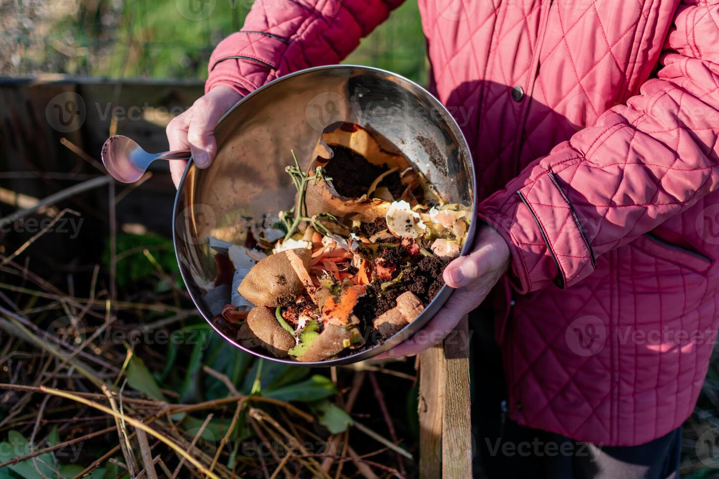 Person who put in a composter some kitchen waste like vegetables, fruits, eggshell, coffee grounds in order to sort and make bio fertilizer photo
