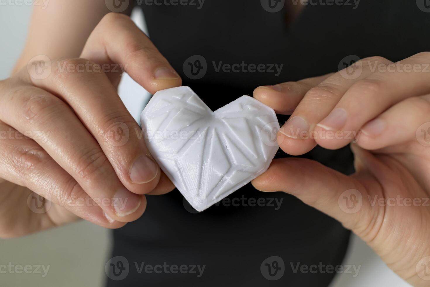 Woman holding white 3d printed heart. Ideal for diverse concept, love and health, gratitude and charity either technology photo