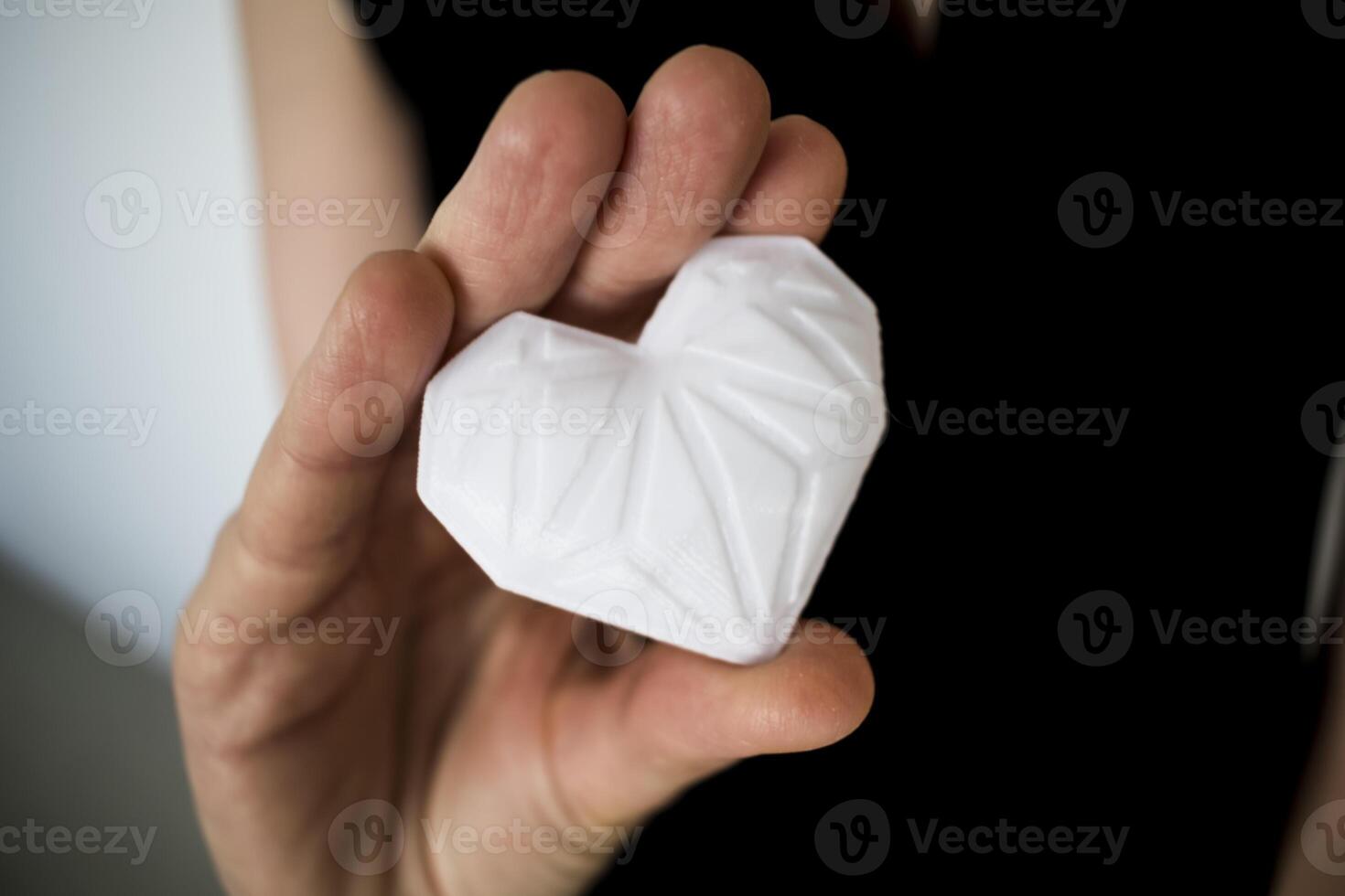 Woman holding white 3d printed heart. Ideal for diverse concept, love and health, gratitude and charity either technology photo