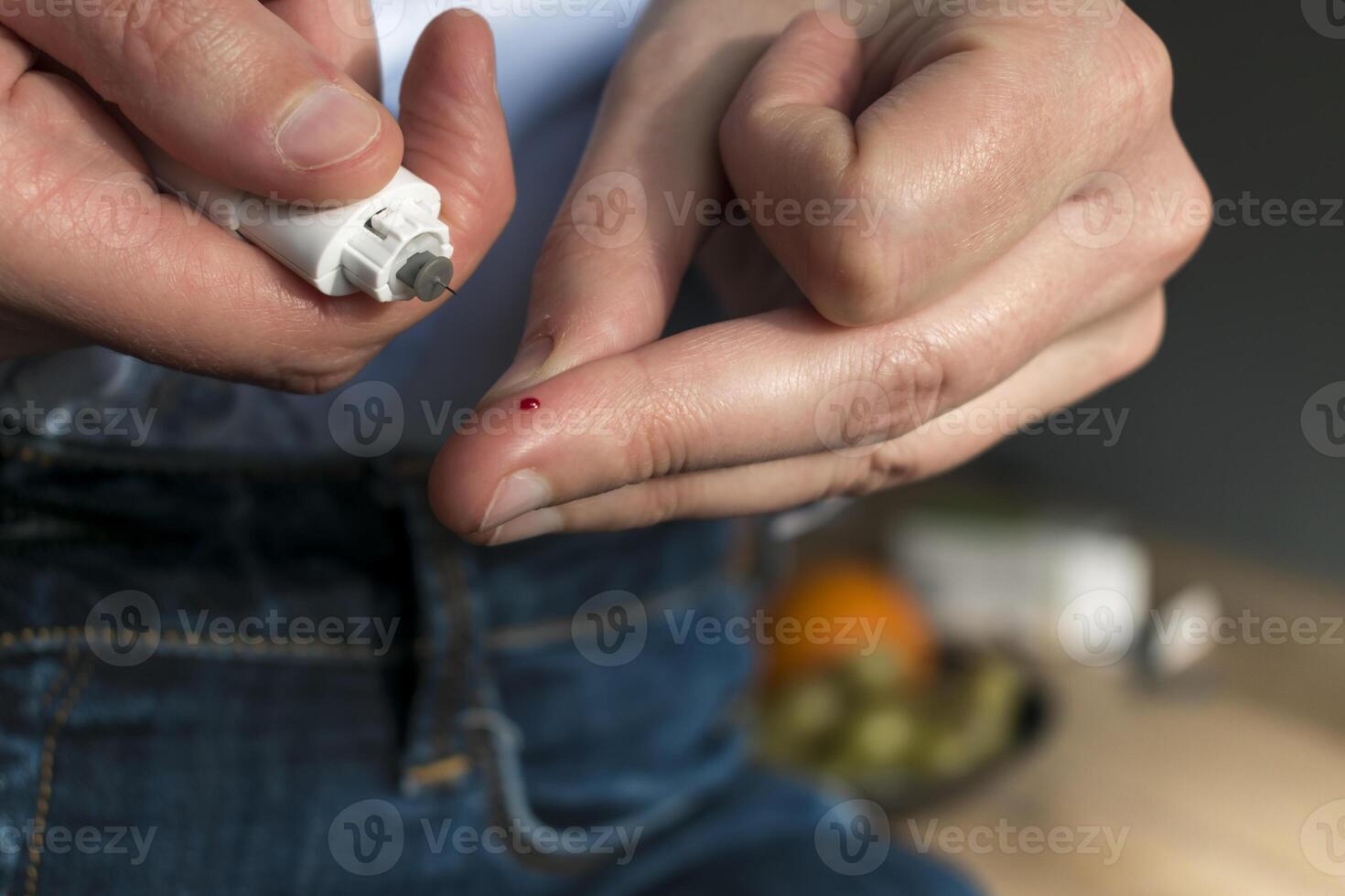 Woman pricking her finger to check blood glucose level with glucometer, test blood glucose for diabetes photo