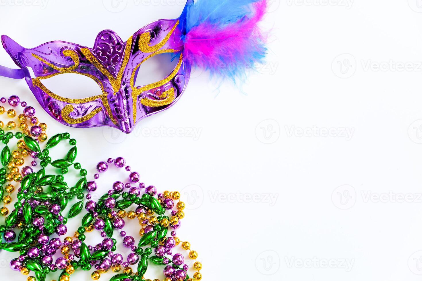 Carnival mask with feathers and colorful beads on white background. Mardi Gras or Fat Tuesday symbol. photo