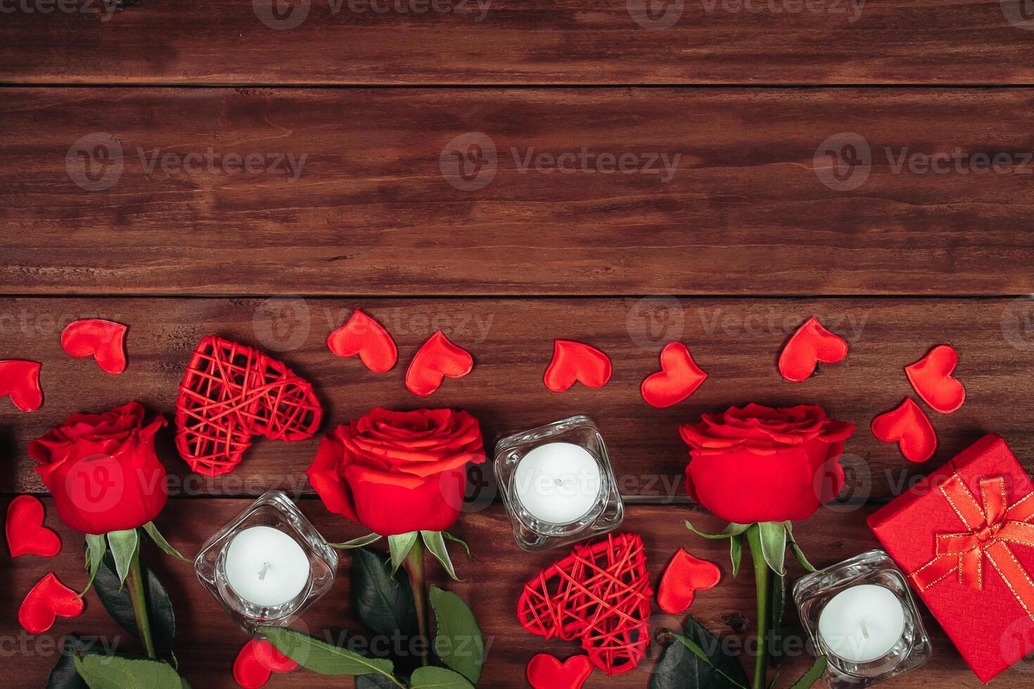 Red roses and hearts on a dark wooden background. Valentine's day postcard concept. photo