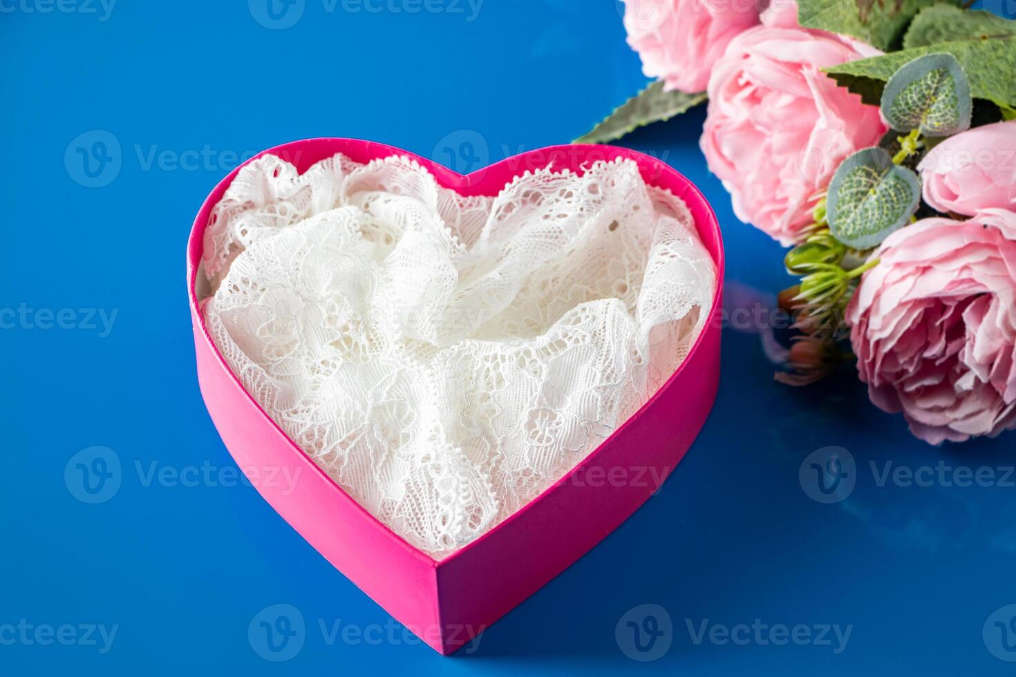 Pink gift box and flowers on a blue background. photo