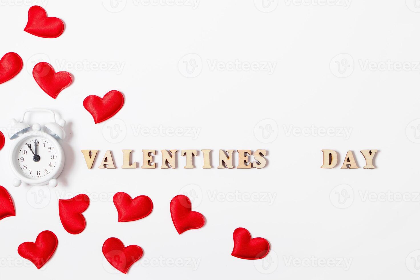 Alarm clock and red hearts on a white background. Valentine's day lettering. photo