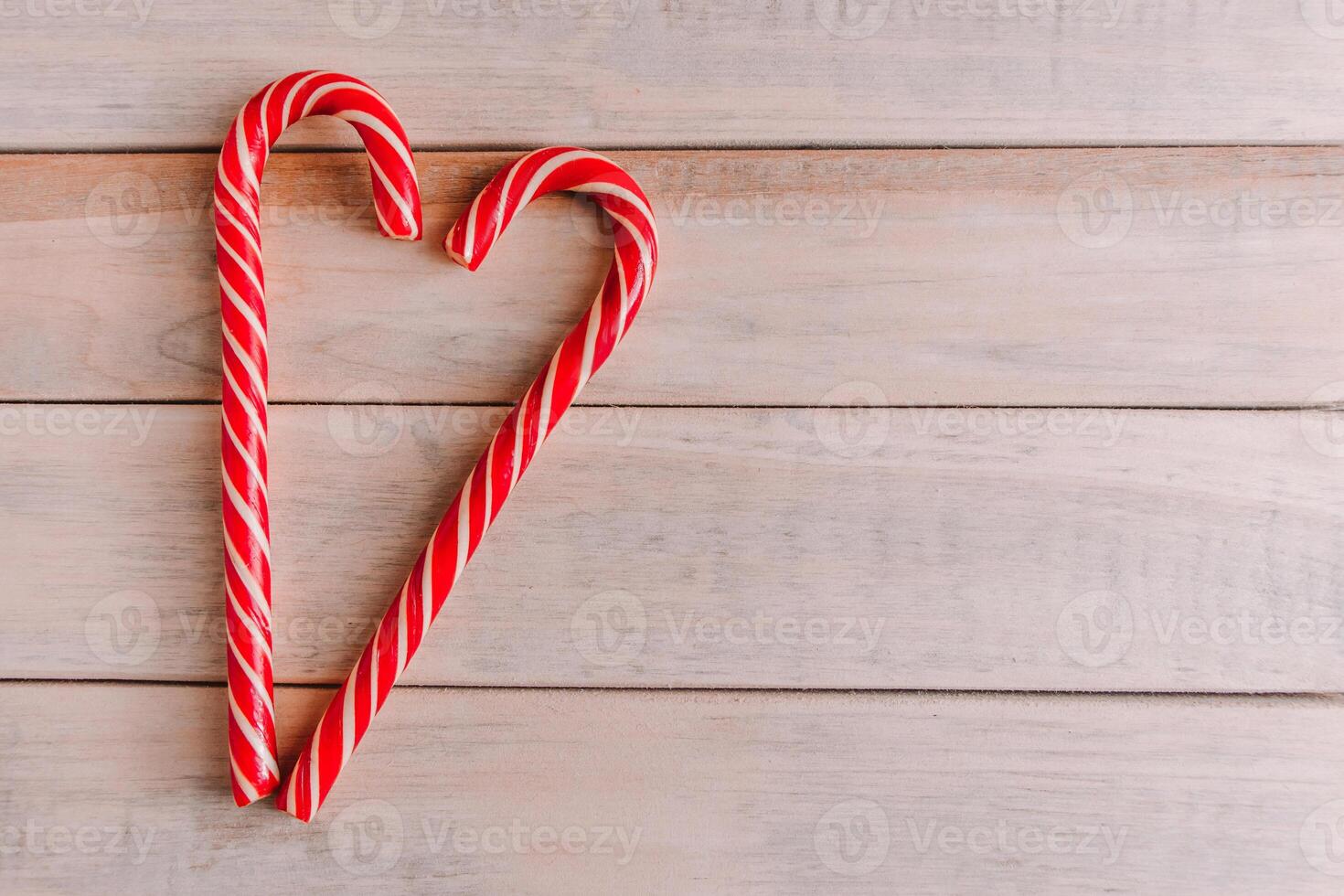 Two Christmas candy canes in the shape of a heart. Valentine's day concept. Place for text. photo