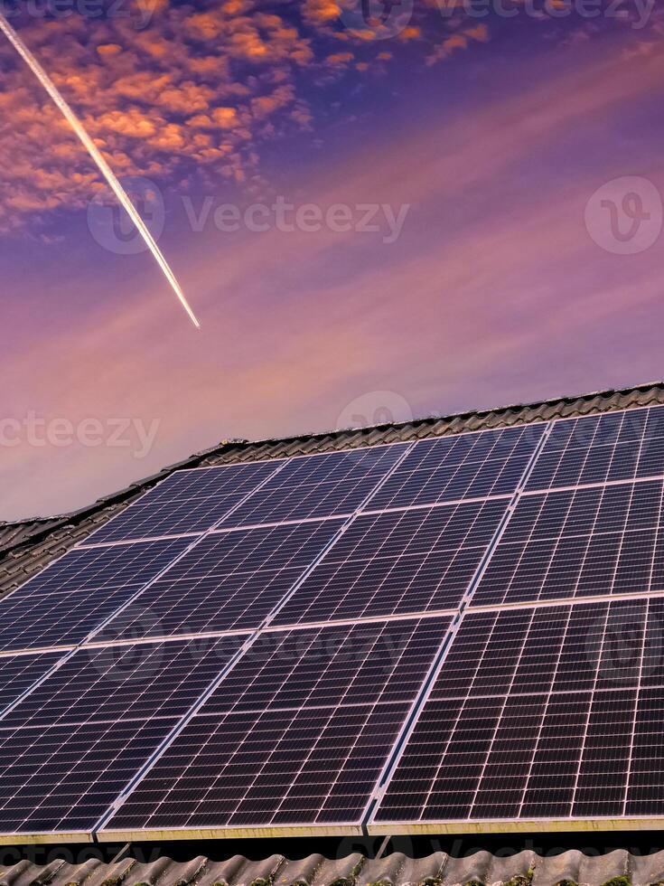 Solar panels producing clean energy on a roof of a residential house photo