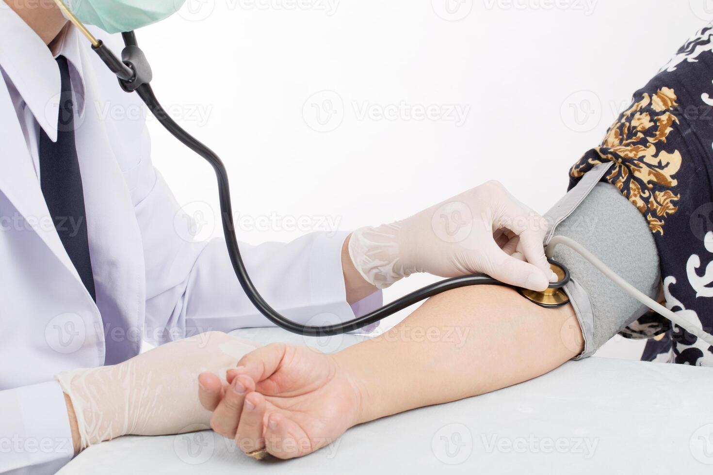 Doctor checking pulse of patient with stethoscope  on table isolated white background. photo