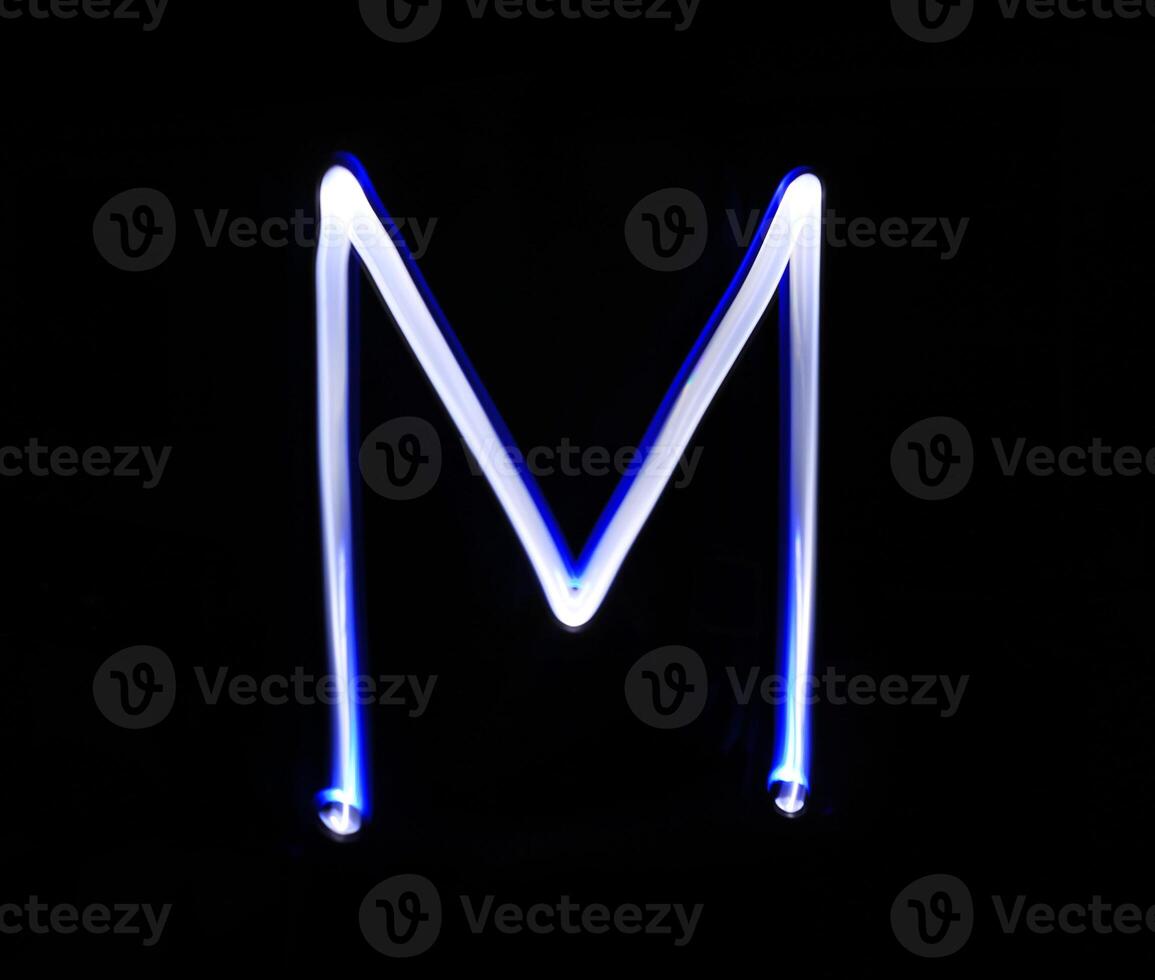 M Mike alphabet hand writing blue light  over black background. photo