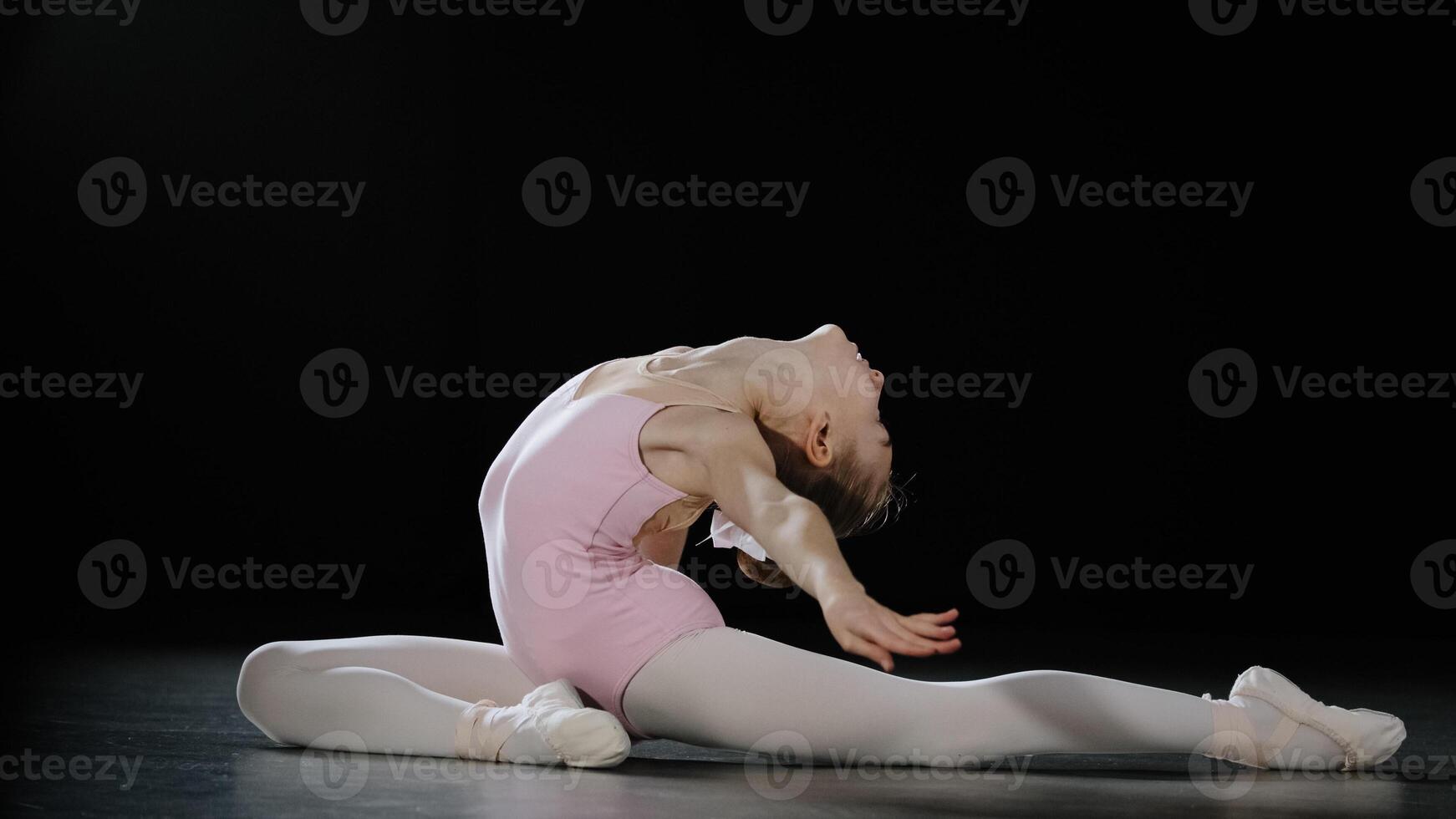 15s girl dancer ballerina teenager gymnast acrobat doing back bend position dancing element stretching exercises athletic child lady flexible dancer practicing gymnastics pose on floor bending body photo