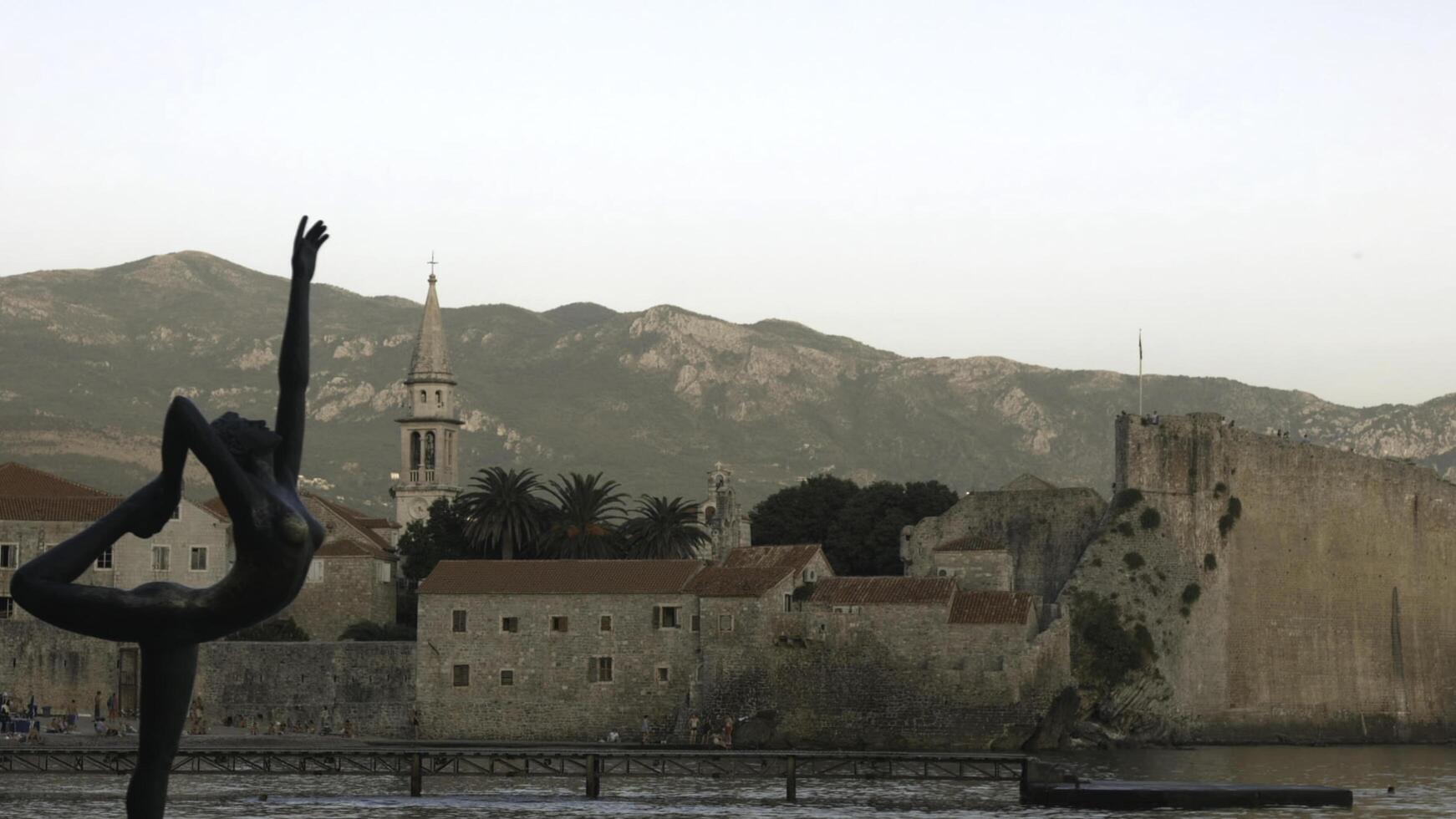 Montenegro, Budva - March 23, 2023. Beautiful monument to ballerina. Creative. Statue of ballerina on background of ancient city. Famous landmark is monument to ballerina in ancient European city photo