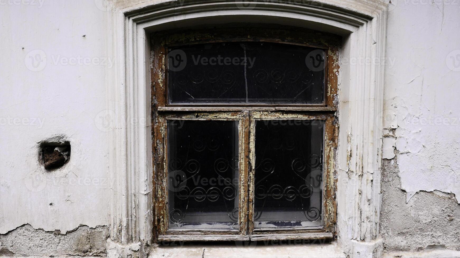 An old dark window. Stock footage. A white old house in which a dark window without light inside is removed in daylight. photo